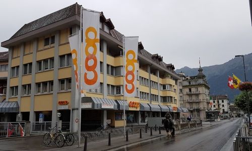 Coop-Geschäft in der Stadt mit Bergkulisse